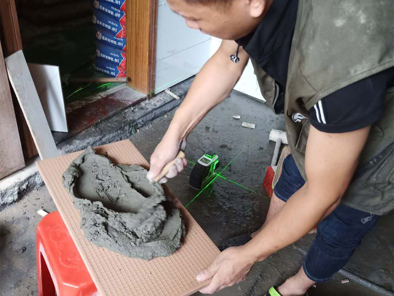 衛(wèi)生間墻面瓷磚鋪貼：首先應(yīng)除去基層表面的污垢，油漬，浮灰;除去基層上所有涂料層，膩?zhàn)訉?如果基層未能達(dá)到平整度要求，需對基層進(jìn)行預(yù)先的找平處理；鋪貼瓷磚前需事先找好垂直線，以此為基準(zhǔn)鋪貼的瓷磚高低均勻、垂直美觀;將調(diào)制好的漿料均勻地抹在瓷磚背面，要求漿料飽滿；將瓷磚平整地鋪貼在基層上，使用橡膠錘將瓷磚拍實(shí)鋪平。