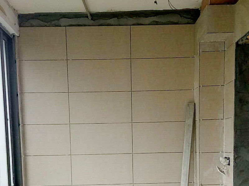 衛(wèi)生間瓷磚鋪貼：基層處理：將凸出墻面的混凝土剔平，對于基體為混凝土表面很光滑的要鑿毛，或用可摻界劑膠的水泥水細(xì)砂漿做小拉毛墻，也可以刷界面劑、并澆水濕潤基層。浸磚：面磚鑲貼前，應(yīng)挑選顏色、規(guī)格一致的磚；浸泡磚時(shí)，將面磚清掃干凈，放入凈水中浸泡2小時(shí)上，取出待表面晾干或擦干凈后方可使用。粘貼面磚：粘貼應(yīng)自下而上進(jìn)行。抹8㎜厚1：0.1：2.5水泥石灰膏砂漿結(jié)合層，要刮平，隨抹隨自上而下粘貼面磚，要求砂漿飽滿，虧灰時(shí)，取下重貼，并隨時(shí)用靠尺檢查整度，同時(shí)保證縫隙寬度一致。