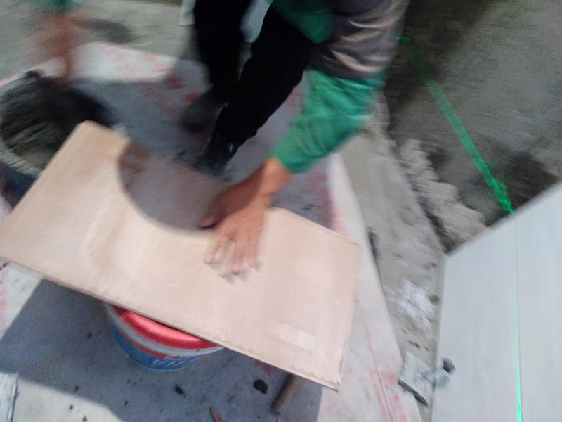 廁所墻面貼瓷磚：廁所貼瓷磚：首先應(yīng)除去基層表面的污垢，油漬，浮灰;除去基層上所有涂料層，膩子層;如果基層未能達到平整度要求，需對基層進行預(yù)先的找平處理；鋪貼瓷磚前需事先找好垂直線，以此為基準鋪貼的瓷磚高低均勻、垂直美觀；應(yīng)對瓷磚的色彩、紋理、表面平整等進行嚴格的挑選，然后按照圖紙要求預(yù)鋪，調(diào)制粘結(jié)劑；然后將調(diào)制好的漿料均勻地抹在瓷磚背面，要求漿料飽滿，瓷磚平整地鋪貼在基層上，使用橡膠錘將瓷磚拍實鋪平；最后瓷磚鋪貼結(jié)束后24小時，可進行嵌縫施工，嵌縫后用浸濕的織物清理多余的嵌縫劑，保持瓷磚表面清潔。
