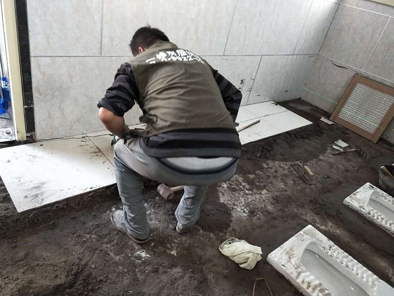 公廁貼磚維修：基層處理：應(yīng)全部清理墻面上的各類污物，打掃干凈現(xiàn)場(chǎng)，特別是腳落里。 批墻、墻面找平：用泥刀先批墻，后用水泥漿找平。這個(gè)工序很重要，確保底子平，防止貼后空鼓。 刷防水涂料：墻面要刷防水涂料，防止貼后浸水，一般高度不低于1.8米，刷的時(shí)候會(huì)稍高一些。 找水平基準(zhǔn)線：根據(jù)設(shè)計(jì)鋪貼圖樣的要求，確定排磚方案，用墨斗彈線，以減少施工損耗。 粘結(jié)劑上墻：把剛剛攪拌好的粘結(jié)劑漿料均勻的刮到墻上。 瓷磚上墻將經(jīng)過預(yù)先清潔的瓷磚平整地鋪貼在粘結(jié)劑漿料基層上，使用橡膠錘將瓷磚拍實(shí)鋪平。施工過程中，可小幅度轉(zhuǎn)動(dòng)瓷磚，使?jié){料與瓷磚背面充分接觸。專家建議在鋪貼時(shí)，隨機(jī)取下已鋪貼于基層上的瓷磚作檢查。確保漿料與瓷磚背面的充分接觸。 留縫大小調(diào)整根據(jù)瓷磚的尺寸，在磚與磚之間預(yù)留相應(yīng)尺寸的縫隙留待嵌縫?？捎醚篮灥认裙潭?，粘結(jié)劑具有一定的可調(diào)整性，可對(duì)留縫的大小進(jìn)行調(diào)整。