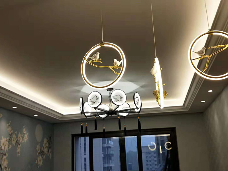 吊燈安裝：一、確定位置  吊燈位置確定之后，還要注意檢測該位置的承重力，畢竟一盞吊燈的重量還是蠻重的，尤其是客餐廳吊燈又大又重，倘若頂面承重力不夠，時間長了會有脫落的危險。所以吊燈安裝位置應(yīng)是實心磚石頂面或墻面，不宜是輕質(zhì)木質(zhì)頂面。 步驟二、拆吊燈面罩  吊燈面罩會有旋轉(zhuǎn)式和卡扣式兩種固定方式，大家拆卸時要小心謹慎，不要弄壞吊燈了。面罩和燈管都要取下來，以免安裝的過程中碰碎燈管。 三、安裝底座  將吊燈底座對著頂面或墻面的安裝位置，找到孔位并標記出來，然后放下底座，使用與孔位規(guī)格相同的電鉆來打孔，天花板孔位一般是在6毫米，打孔完畢后就可以安裝膨脹螺栓了，這是固定吊燈底座用的，不過要注意孔的深度，要把膨脹螺絲塞入孔內(nèi)，使用錘子把它敲進去，之后將底座與膨脹螺栓擰緊、固定，要與預(yù)先確定的安裝位置相同，不能有偏移的情況。 四、連接燈線   吊燈底座固定后，就可以連接燈線與電源線了，不過要注意連接的兩個線頭要接觸良好，需用黑膠布包裹好，并注意保持間距，盡量不把兩個連接頭放在一塊金屬片下，防止產(chǎn)生短路帶來危險。連接好燈線與電源線后就可以安裝燈管，這時可通電檢查，看看能否正常使用，如不正常要檢查線路，若一切OK，那么就要關(guān)閉電源再繼續(xù)吊燈后續(xù)安裝。