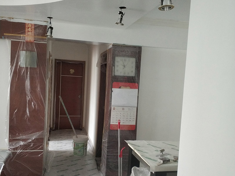 墻面翻新，地面保護：為了避免施工中磕碰到業(yè)主的家俱等物件，特地將這些物件搬到房屋中間。很快房間內(nèi)可以搬動的物件，就都搬到了房屋的中間位置。為了避免涂料意外滴上，包上了保護膜。在鏟除舊墻面時還會留心用小托盤接住，以免弄臟業(yè)主家的地面。將踢腳線等與墻面接觸的位置及地面做好遮蔽，以免將涂料碰到木器上。 墻面應先除掉浮灰，鏟除起砂翹皮的位置;對油污的位置，應先將原有涂層鏟掉，不能鏟掉的要徹底清洗干凈。選用顆粒細度較大和質(zhì)地較硬的膩子刮凃，底漆必須要刷勻，保證墻面每個地方都刷到，如果墻面吃漆量較多，底漆最好適當?shù)募右稽c水，以保證可以涂刷均勻。這里上漆的量就是通常上的上漆工作了，不能加過量的水，會對漆膜厚度、手感和漆膜的硬度等產(chǎn)生影響。