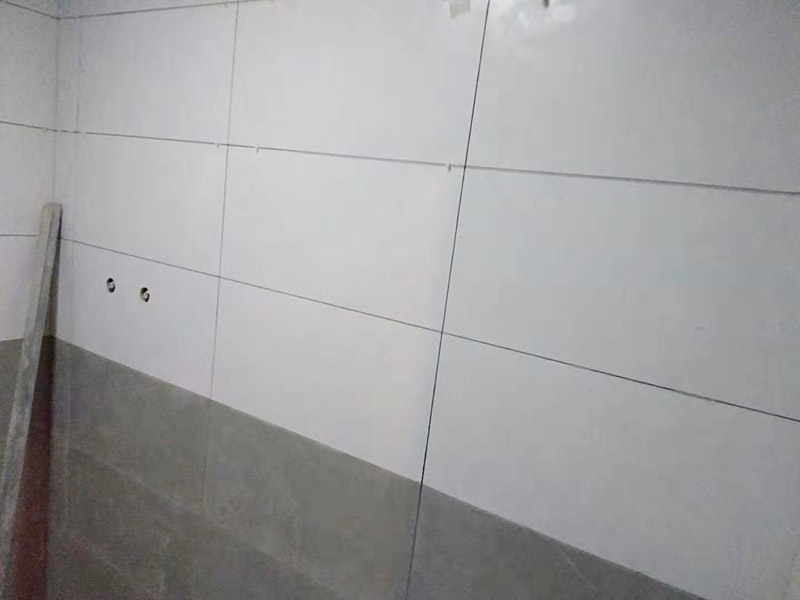 浴室墻面貼瓷磚：貼瓷磚之前先要用水浸泡瓷磚2小時(shí)左右。泡水的目的是為了讓瓷磚能事先吸飽水分，避免鋪貼之后吸走粘接材料中的水分，從而影響粘接的強(qiáng)度，浸水后記得用棉布擦去表面的水分晾干后才能進(jìn)行鋪貼。鋪貼開(kāi)始前還應(yīng)吊垂線(xiàn)，來(lái)確定瓷磚的尺寸線(xiàn)，然后開(kāi)始貼瓷磚，一般都是從門(mén)窗先開(kāi)始，而且按由下而上，自左至右的順序進(jìn)行。鋪貼的方法是先用水潤(rùn)濕找平層，然后用鏟子將事先拌好的粘接材料抹在瓷磚背面，再將瓷磚貼在墻上即可，依次鋪貼平整就可以了。