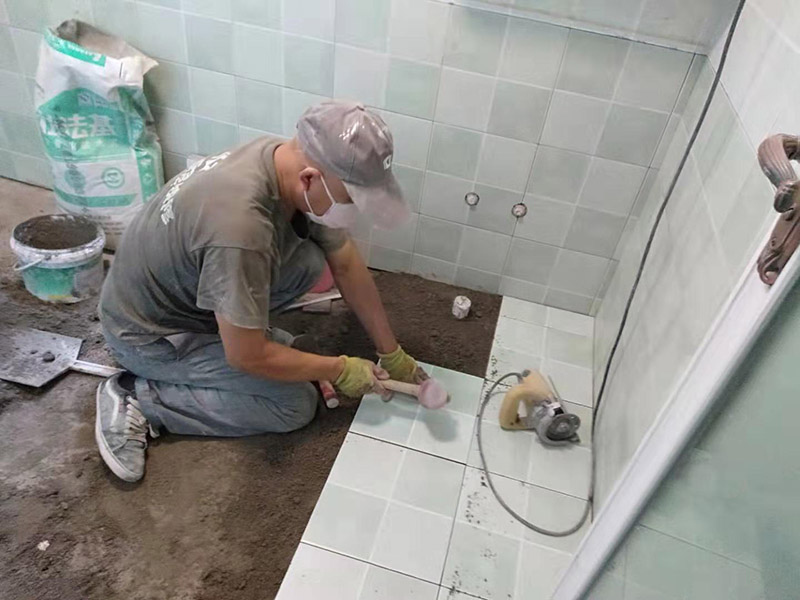 廁所地面貼瓷磚：首先將選購(gòu)好的瓷磚清潔干凈，并du在水中浸泡2個(gè)小時(shí)以上，瓷磚的浸泡是為了能讓瓷磚充分的吸收水分，避免在鋪貼完成之后吸取材料中的水分，而影響瓷磚與地面的粘貼度，造成起空鼓、脫落等現(xiàn)象，開(kāi)始鋪貼瓷磚之前需要從水中取出并將便面的水分擦去，以便鋪貼。 設(shè)置輔助線(xiàn)在開(kāi)始瓷磚進(jìn)行鋪貼之前，需先在墻面上吊垂線(xiàn)，吊垂線(xiàn)是用來(lái)確定瓷磚與墻面的尺寸，再設(shè)置水平線(xiàn)，這樣能夠保證瓷磚鋪貼過(guò)程中保持橫平豎直的平整度。 順序鋪貼通常地磚的鋪貼都是由門(mén)窗邊或者陽(yáng)臺(tái)開(kāi)始的，保證從上到下，由左及右的順序行進(jìn)，先用水潤(rùn)曾找平層，再用鏟子將水泥抹在瓷磚的背面，再將瓷磚貼在地面，再用橡膠錘輕輕敲擊瓷磚，使水泥充滿(mǎn)墻面與瓷磚之間的空隙。