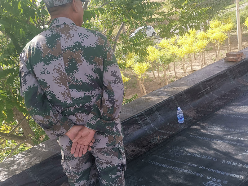 屋頂防水卷材鋪貼:清除基層表面雜物、油污、砂子，凸出表面的石子、砂漿疙瘩等應(yīng)清理干凈，清掃工作必須在施工中隨時進行，并修補平整表面。尤其鏟除排水口、煙囪、管壁上的水泥砂漿等附著物；根據(jù)施工現(xiàn)場狀況，進行合理定位，確定卷材鋪貼方向，在基層上彈好卷材控制線，依循流水方向從低往高進行卷材試鋪。卷材試鋪后，先將要鋪貼的卷材剪好，反鋪于基面上(即是底部隔離紙朝上)，撕剝?nèi)ゾ聿母綦x紙。撕剝時，已剝開的隔離紙宜與粘結(jié)面保持45～60度的銳角，防止拉斷隔離紙，盡量保持在自然松弛狀態(tài)，但不要有皺折。