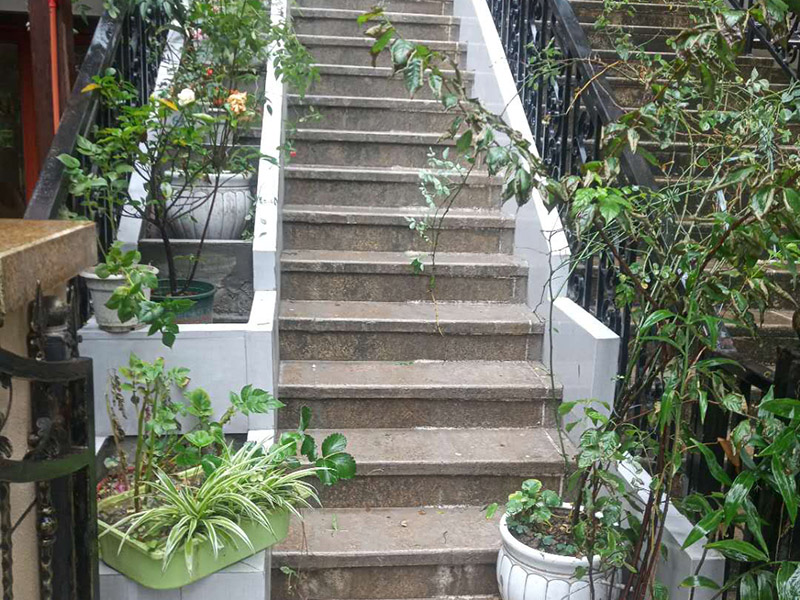 戶外樓梯加花壇：用測量儀器把花壇群中主花壇中心點坐標測量到地面上，再把縱橫中軸線上的其他中心點的坐標測設下來，將各中心點連線，即在地面上放出花壇群的縱橫軸線。放線完成后，應沿著已有的花壇邊線開挖邊緣石基槽?；鄣拈_挖寬度應比邊緣石基礎寬10厘米左右，深度可在12～20厘米之間。槽底土面要整平、夯實，有松軟處要進行加固，不得留下不均勻沉降的隱患。在砌基礎之前，槽底還應做一個3～5厘米厚的粗砂墊層，用于基礎施工找平。
