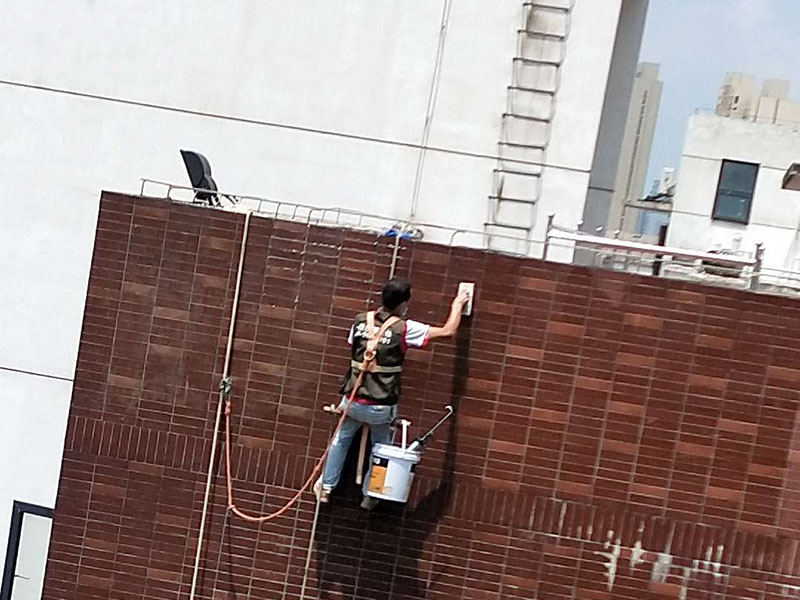 高空外墻防水：外墻面洞和較大裂縫防水密封前用噴水槍等工具將待治理的外墻面、伸縮縫、窗框等部位清理干凈，使施工的外墻面及縫、孔、洞部位達到無油、無塵土、無水泥松散顆粒等雜物。   待其干燥后，將孔、洞、縫用防水密封材料嵌填密實，并達到與原顏色一致，再用快速堵漏靈和透明防水膠膜進行精心施工。整體條形瓷磚外墻面防水，采用高效環(huán)保型憎水進行精心施工。該材料具有防水性能優(yōu)異、透氣性能良好、施工方便、使用安全、質量可靠、耐久性好等特點。