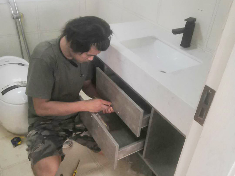 浴室柜及燈具安裝：安裝前，檢查零配件是否齊全。安裝三角閥，確保冷熱進水管保持齊平。測量距離，安裝下水管。涂抹膠水要均勻，確保管與管間連接緊密。安裝柜角，看所有角是否在同一水平。裝好后可做適當(dāng)?shù)恼{(diào)整。將浴室柜靠墻放好?？催M出水管位置是否得當(dāng)，不合適時需做一定改動。安裝臺盆的龍頭。龍頭最好與浴室柜配套購買，這樣出水角度較為適合。用螺母固定臺盆龍頭。固定時一只手要扶好龍頭，以免裝好后位置偏離。將裝好龍頭的臺盆放在浴室柜上，調(diào)整位置到最佳為止。連接臺盆的進出水管及下水，長度適當(dāng)，位置合理。裝好柜體的把手，并進行適
