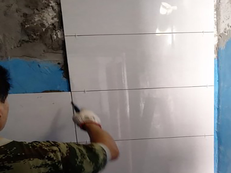 墻面瓷磚鋪貼施工：（1）基層處理：將塵土、雜物徹底清掃干凈，不得有空鼓、開裂及起砂等缺陷。 （2）彈線：施工前在墻體四周彈出標(biāo)高控制線，在地面彈出十字線，以控制地磚分隔尺寸。 （3）鋪貼：鋪設(shè)選用1：3干硬性水泥砂漿，砂漿厚度25mm左右。鋪貼前將地磚背面濕潤(rùn)，需正面干燥為宜。把地磚按照要求放在水泥砂漿上，用橡皮錘輕敲地磚飾面直至密實(shí)平整達(dá)到要求。 （4）勾縫：地磚鋪完后24h進(jìn)行清理勾縫，勾縫前應(yīng)先將地磚縫隙內(nèi)雜質(zhì)擦凈，用專用填縫劑勾縫。 （5）清理：施工過程中隨干隨清，完工后(一般宜在24h之后)再用棉紗等物對(duì)地磚表面進(jìn)行清理