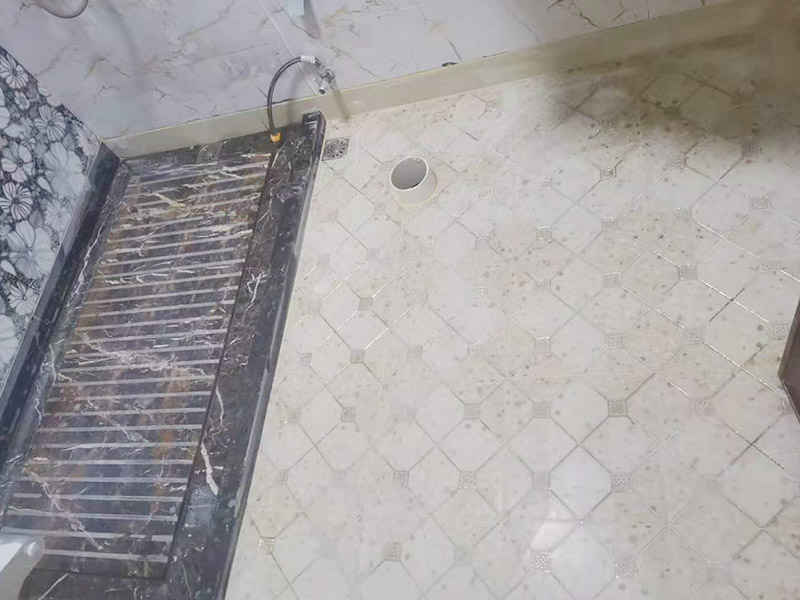 衛(wèi)生間地面防水裝修:首先要將墻面地面都要清潔干凈，這點(diǎn)非常重要，不能有散沙、土、石塊等干擾基層。如果基層開(kāi)發(fā)商做的很不好的話，表面還要刷一層界面劑以防止墻面表面起沙。用噴壺將陰角部分和管根部分噴水，噴水的主要目的就是防止墻面吸收了堵漏寶太多的水分，造成堵漏寶沒(méi)有和墻面凝結(jié)在一起。那么噴多少水呢，建議以表面沒(méi)有明顯積水為宜。刷完以后，由于速凝型的堵漏寶干燥較快，所以基本不用等待，干的非?？臁Ｈ缓髮⒌谝槐槎侣毶箱伜镁W(wǎng)格布，主要是防止堵漏寶初凝以后裂開(kāi)。然后進(jìn)行第二遍涂刷堵漏寶，刷完咱們就要進(jìn)行下面柔韌性防水涂刷的步驟了。