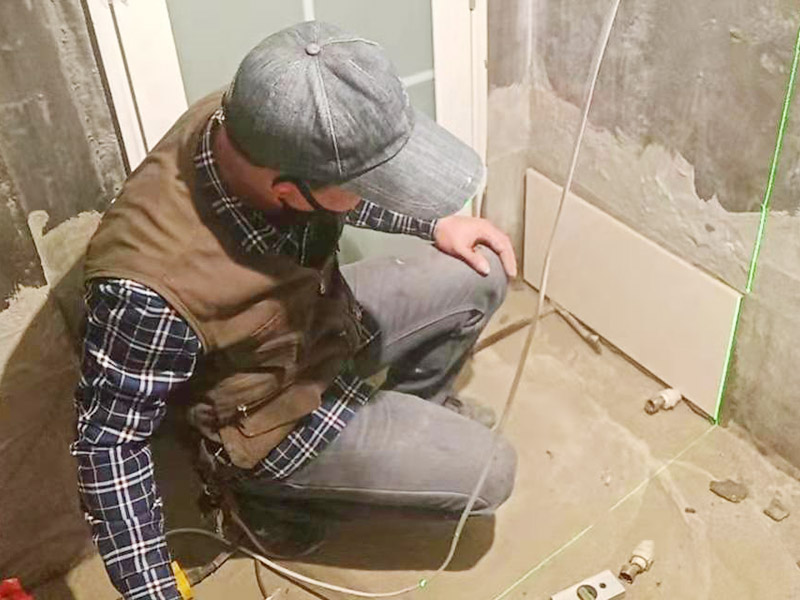 衛(wèi)生間墻面貼磚：施工前將需要的材料整齊堆放在一旁待用。首先應除去基層表面的污垢，油漬，浮灰;除去基層上所有涂料層，膩子層;如果基層未能達到平整度要求，需對基層進行預先的找平處理。 鋪貼瓷磚前需事先找好垂直線，以此為基準鋪貼的瓷磚高低均勻、垂直美觀;此外，施工前在墻體四周需彈出標高控制線，在地面彈出十字線，以控制地磚分隔尺寸。 加水后將粘結劑漿料攪拌至潤滑均勻，無明顯塊狀或糊狀結塊，攪拌后的漿料靜置5-10分鐘后再稍加攪拌1-2分鐘即可使用。在開始鋪貼施工前，需要先清理瓷磚表面的浮灰，污垢等。將調制好的漿料均勻地抹在瓷磚背面，要求漿料飽滿。將瓷磚平整地鋪貼在基層上，使用橡膠錘將瓷磚拍實鋪平。施工過程中，可小幅度轉動瓷磚，使?jié){料與瓷磚背面充分接觸。