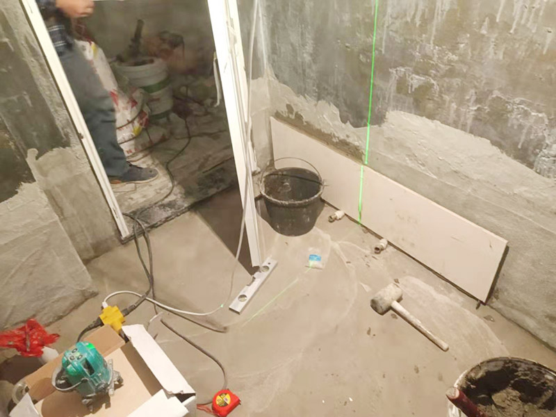 衛(wèi)生間墻面貼磚：施工前將需要的材料整齊堆放在一旁待用。首先應除去基層表面的污垢，油漬，浮灰;除去基層上所有涂料層，膩子層;如果基層未能達到平整度要求，需對基層進行預先的找平處理。 鋪貼瓷磚前需事先找好垂直線，以此為基準鋪貼的瓷磚高低均勻、垂直美觀;此外，施工前在墻體四周需彈出標高控制線，在地面彈出十字線，以控制地磚分隔尺寸。 加水后將粘結劑漿料攪拌至潤滑均勻，無明顯塊狀或糊狀結塊，攪拌后的漿料靜置5-10分鐘后再稍加攪拌1-2分鐘即可使用。在開始鋪貼施工前，需要先清理瓷磚表面的浮灰，污垢等。將調制好的漿料均勻地抹在瓷磚背面，要求漿料飽滿。將瓷磚平整地鋪貼在基層上，使用橡膠錘將瓷磚拍實鋪平。施工過程中，可小幅度轉動瓷磚，使?jié){料與瓷磚背面充分接觸。