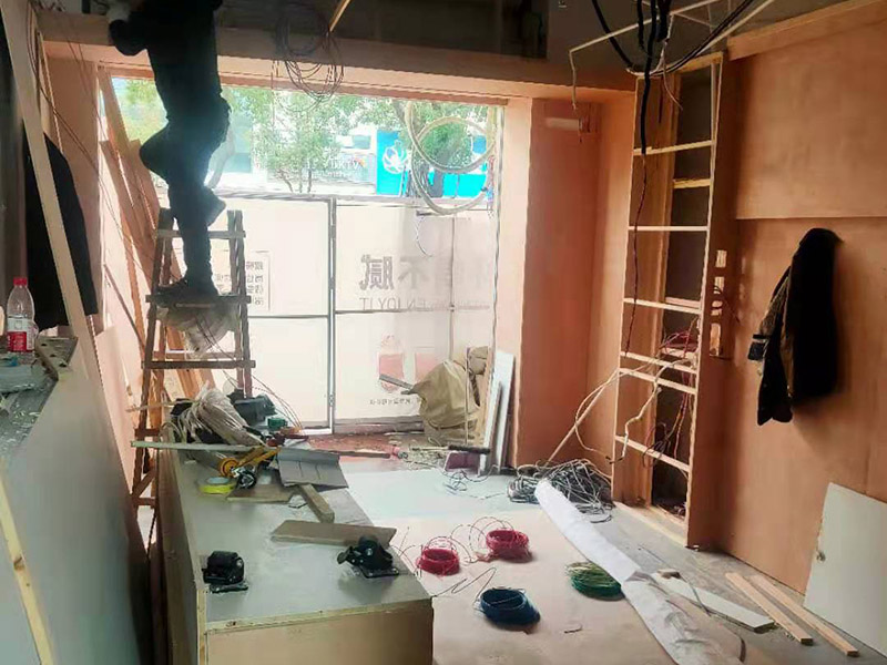 門店木工施工現(xiàn)場(chǎng):首先應(yīng)該搭建木作施工臺(tái)。木作施工臺(tái)用于板材的切割板，板材的造型，板材的平整度處理等等。門窗的制作包括門窗套制作、門窗制作。要特別注意門窗扇與框之間的縫隙不能太大，以及門窗套與門窗的色差等。木作表層封裝木制品制作完成后，對(duì)其表面進(jìn)行細(xì)節(jié)封裝。木作表層封裝通常就要用到各種各樣的家裝板材，特別注意板材的選購(gòu)。