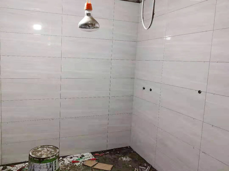 浴室貼磚裝修:把還沒有涂抹水泥的地磚鋪在地上，把它們敲平，然后在地磚上涂滿水泥，鋪在地面，保持四塊磚的對角位置對齊。 鋪瓷磚的順序其實也是有不少講究的，鋪地磚的時候應(yīng)該從內(nèi)向外貼，遇到坡度或者有地漏的地方，還要注意排水方向找坡；墻面磚的鋪貼應(yīng)該從下向上進行。為了最后的鋪貼效果美觀，最底層的瓷磚要最后貼；墻面磚鋪貼結(jié)束以后還要壓地磚。 這里要注意的是，貼瓷磚的時候不能一面墻貼到頂，否則由于瓷磚較重容易引起脫落。鋪好了地磚盡量不要去踩。 因為瓷磚本身有許多小孔，吸水能力強，干燥的瓷磚會吸干水泥的水分.