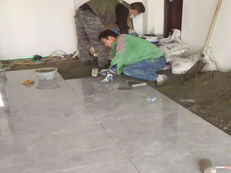 客廳地面貼磚：首先要把基層用水澆濕，除去雜物和浮沙。再抹結(jié)合層，需要注意的是要使用1：3的干性水泥漿，按照水平線探鋪平整，然后再把磚放在沙漿上用膠皮錘振實(shí)。這時再把地面磚取下澆抹水泥漿，然后把地面磚放實(shí)振平就可以了。采用干鋪法可以有效地避免鋪裝過程中造成的空鼓、氣泡等現(xiàn)象發(fā)生。但是干鋪法的技術(shù)含量比較高，所以費(fèi)用也會比較貴。