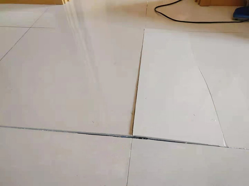 客廳地磚起翹修復(fù)：將油灰刀的邊緣滑入松散的瓷磚與其旁邊的瓷磚之間的接縫中。撬起瓷磚并將其移除。用金屬刮刀或小的撬桿的平坦邊緣刮掉基材和瓷磚背面的稀釋劑或瓷磚粘合劑。用相同的工具刮擦周?chē)臻g的舊水泥漿。用清水沖洗除去翹起的瓷磚，然后用濕海綿擦拭，使其干凈。將砂漿抹在缺口邊緣上，然后將稀釋水泥砂漿抹在瓷磚的背面，將瓷磚鋪回原位。如果難以將瓷磚平整，則將瓷磚墊片插入接縫或修補(bǔ)物與包圍它的瓷磚之間的接縫或接縫中。刮掉多余的漿液，并讓該區(qū)域靜置約10分鐘。用水蘸軟海綿，然后輕輕擦拭修復(fù)區(qū)域。瓷磚上出現(xiàn)一層干粉后，請(qǐng)用干抹布擦拭。